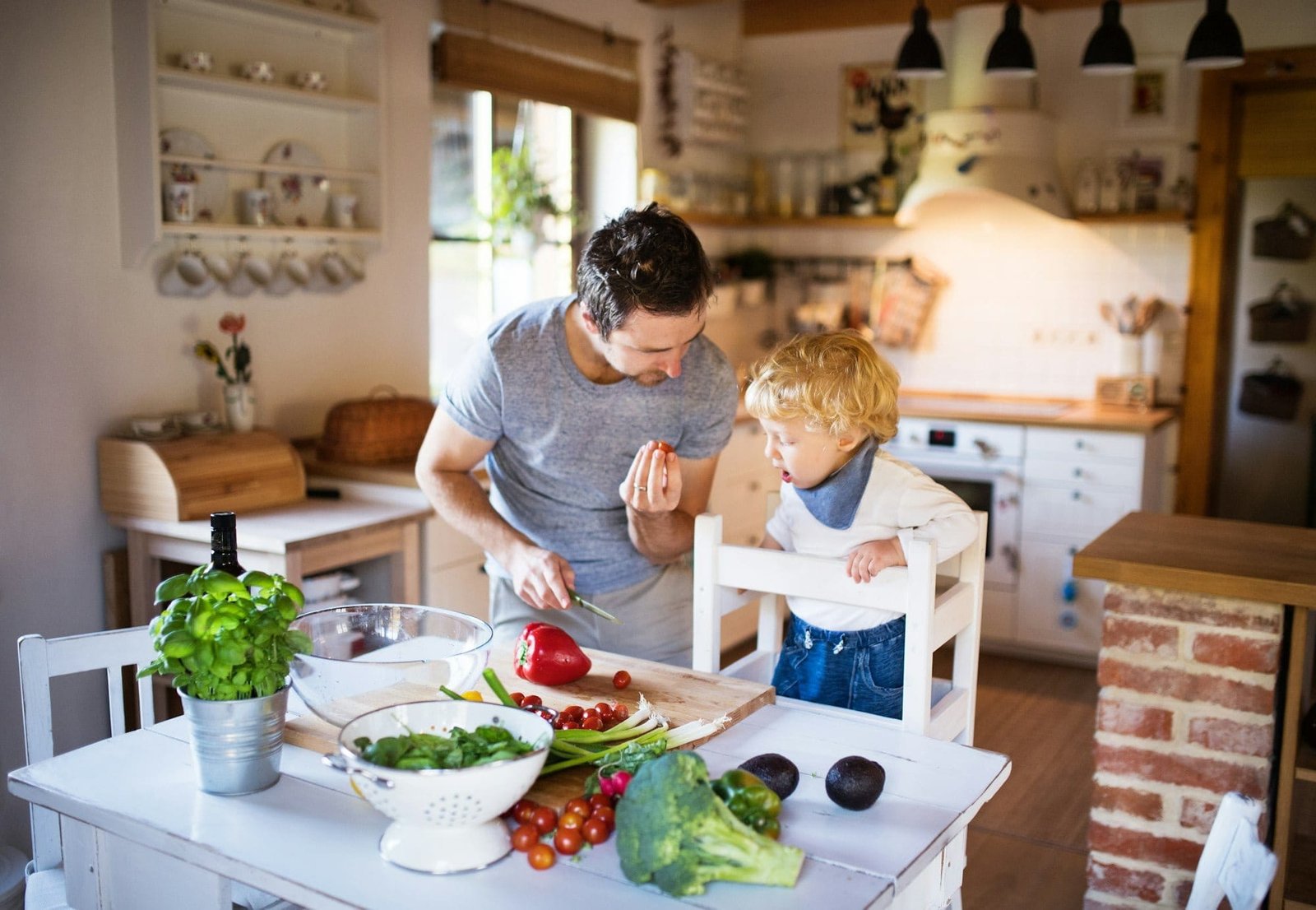 Young father with a toddler boy cooking.